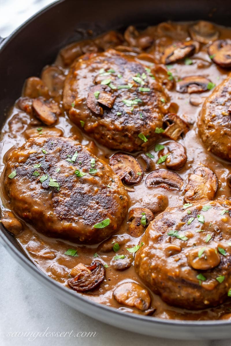 Cast iron skillet with Salisbury steaks in mushroom gravy