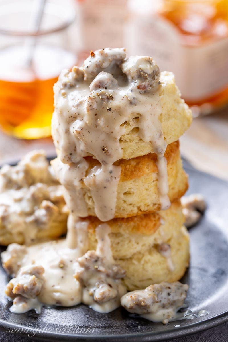A stack of buttermilk biscuits covered with sausage gravy
