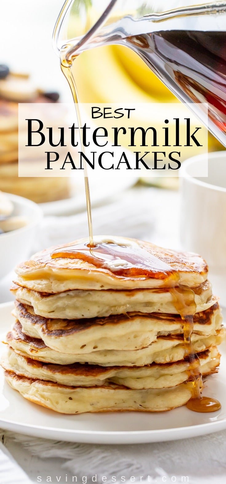 A stack of buttermilk pancakes with maple syrup poured over the top