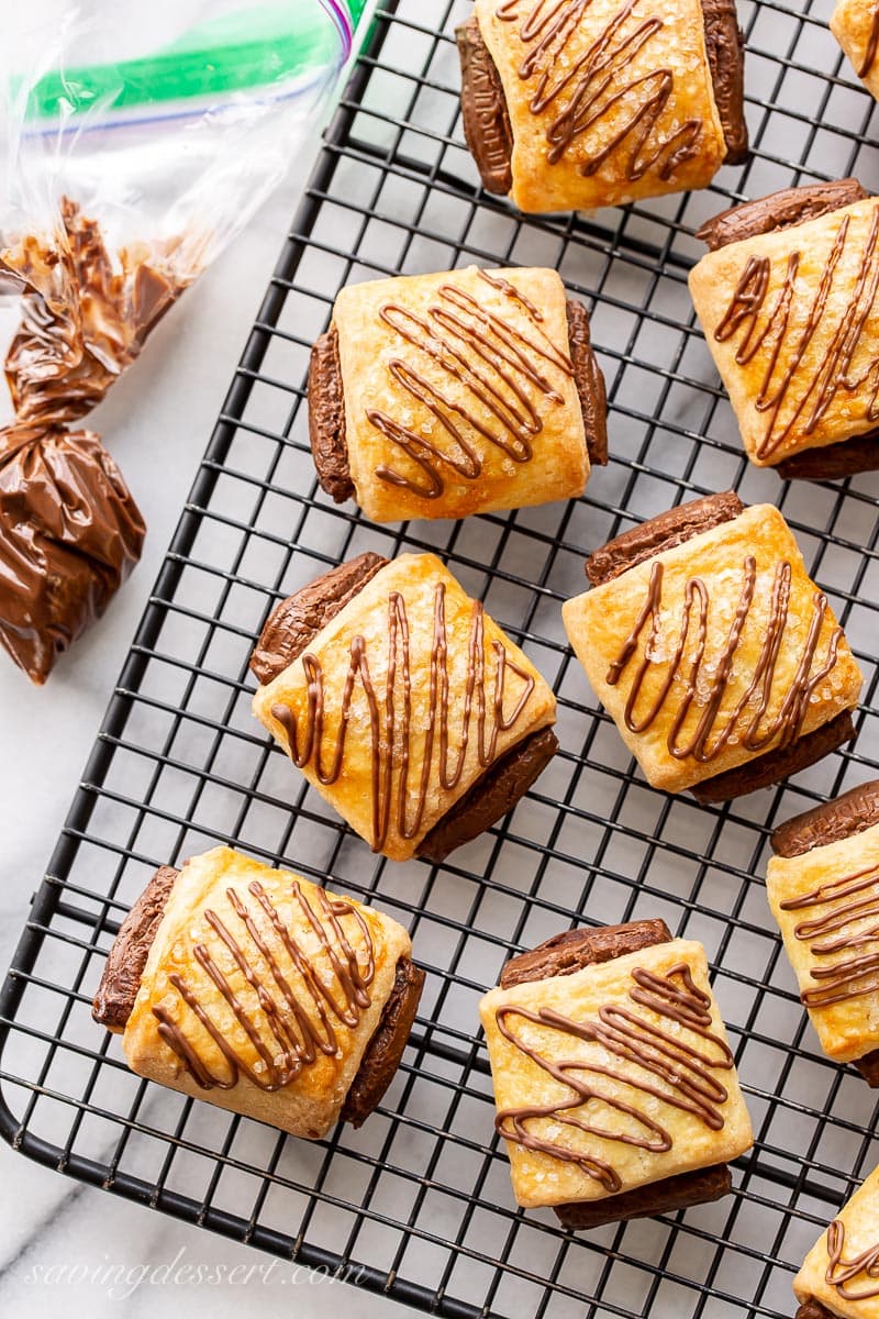 A cooling rack with chocolate croissant cookies drizzled with melted chocolate