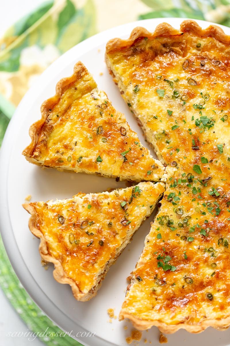 An overhead view of a sliced quiche Lorraine topped with parsley