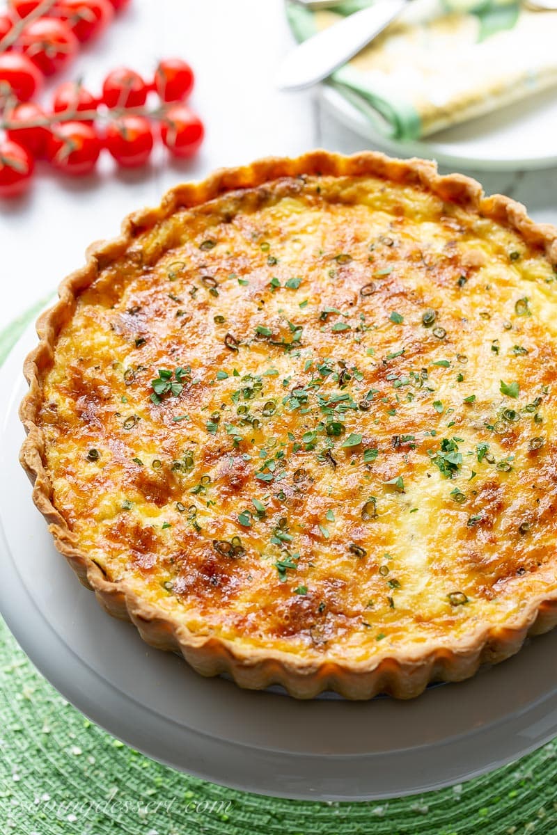 an overhead view of a classic Quiche Lorraine served with tomatoes