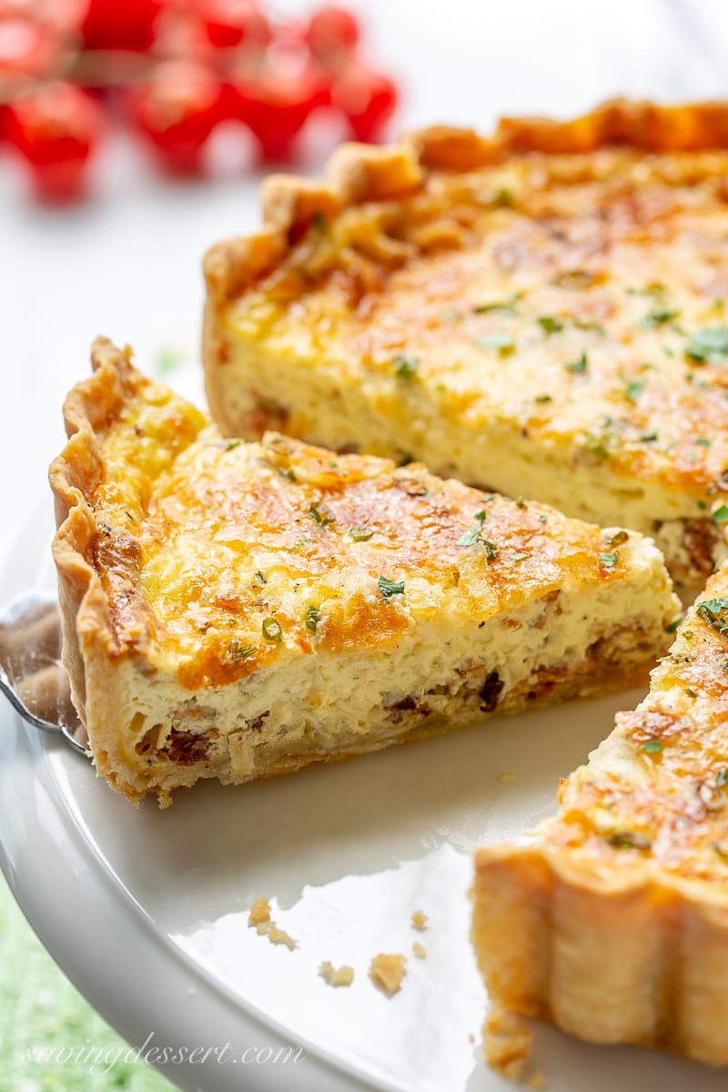 A sliced quiche on a cake platter