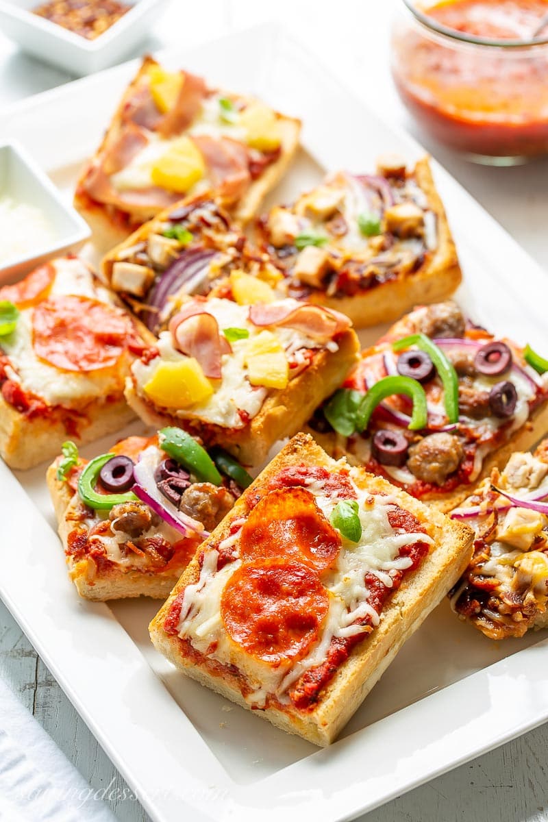 A platter filled with a variety of French bread pizzas