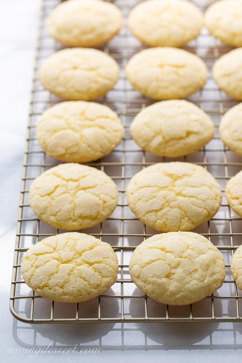 A cooling rack stacked with lemon cookies