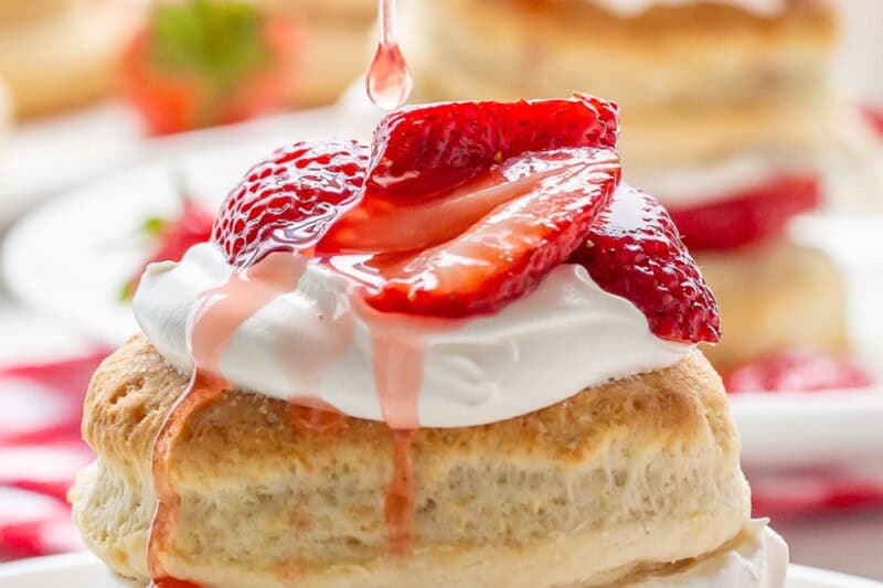 Strawberry Shortcakes being drizzled with juices.