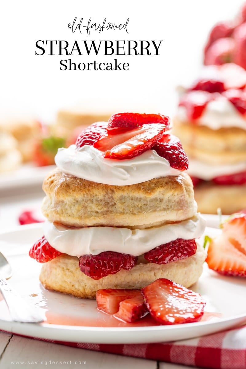 A stacked strawberry shortcake biscuit layered with whipped cream and sliced strawberries