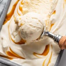 A pan filled with creamy caramel ice cream in a scoop