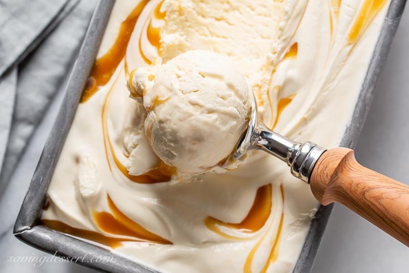 A pan filled with creamy caramel ice cream in a scoop