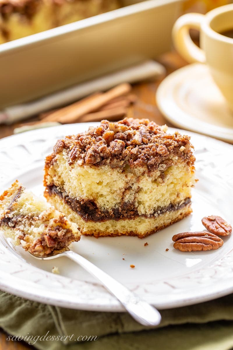 A fork full of cinnamon coffee cake with pecans