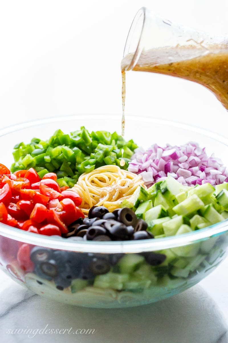 A bowl of fresh vegetables drizzled with Italian dressing