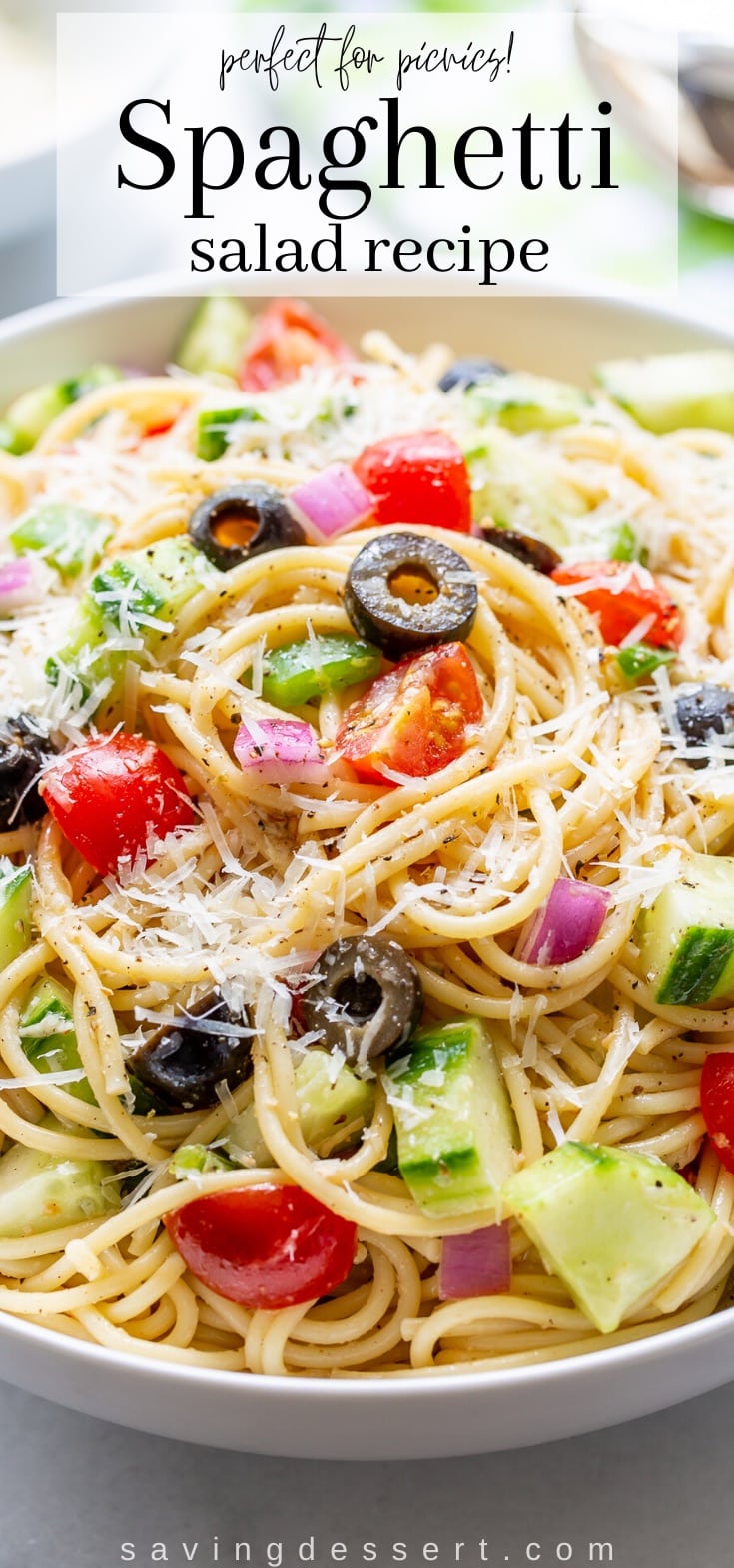A bowl of spaghetti with red onion, olives, cucumbers and tomatoes tossed in an Italian dressing