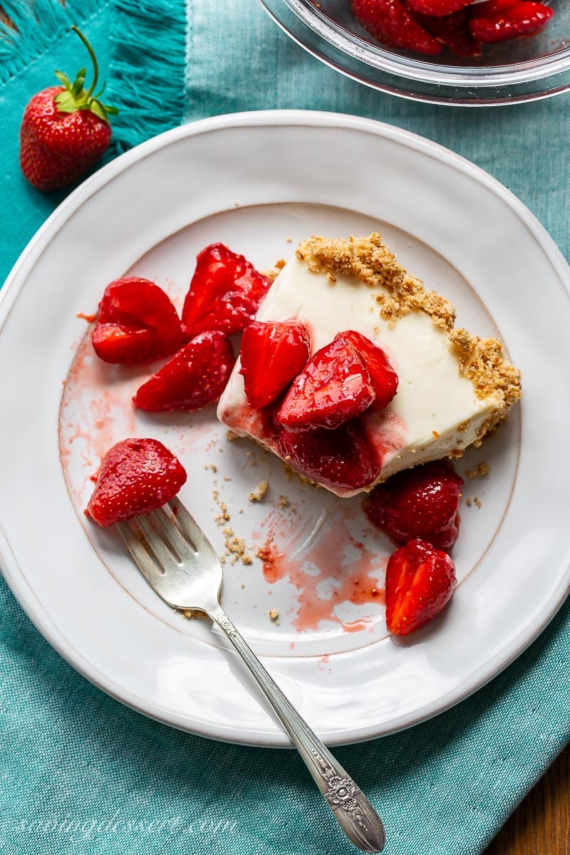 A half eaten slice of pie topped with strawberries