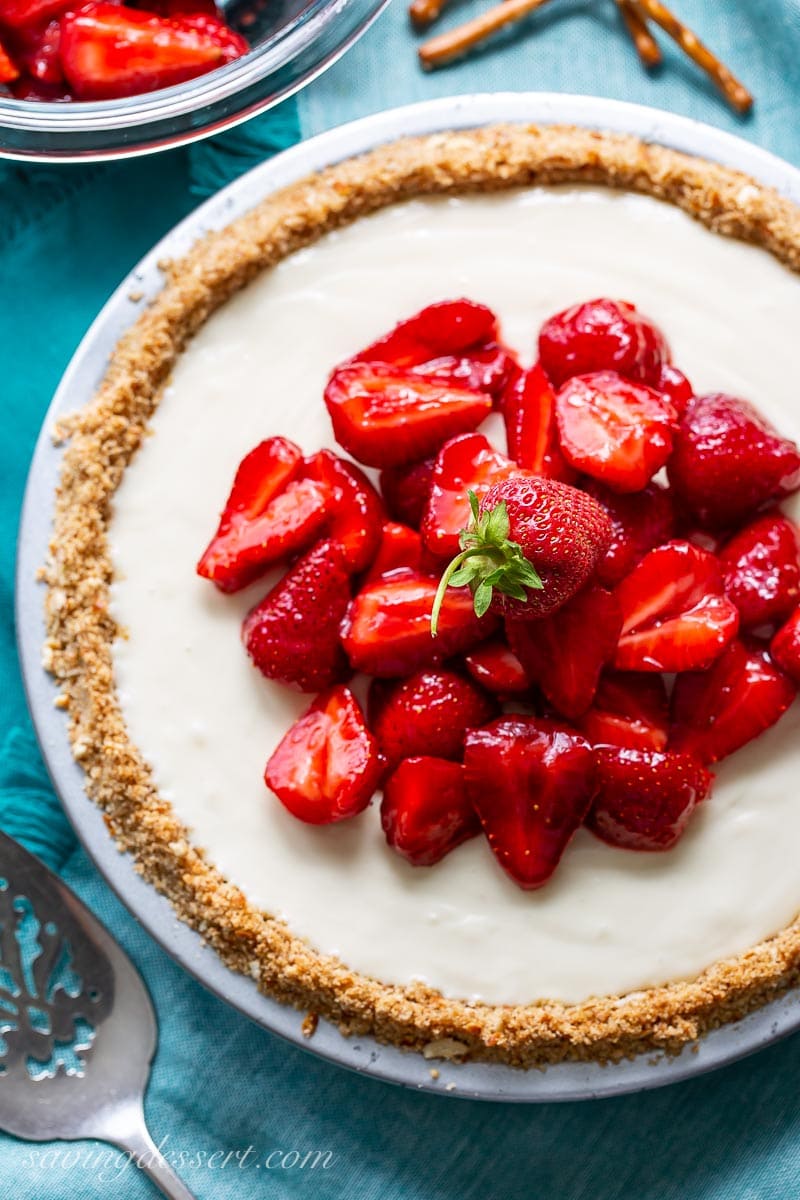 An overhead view of a cream cheese pie topped with fresh strawberries