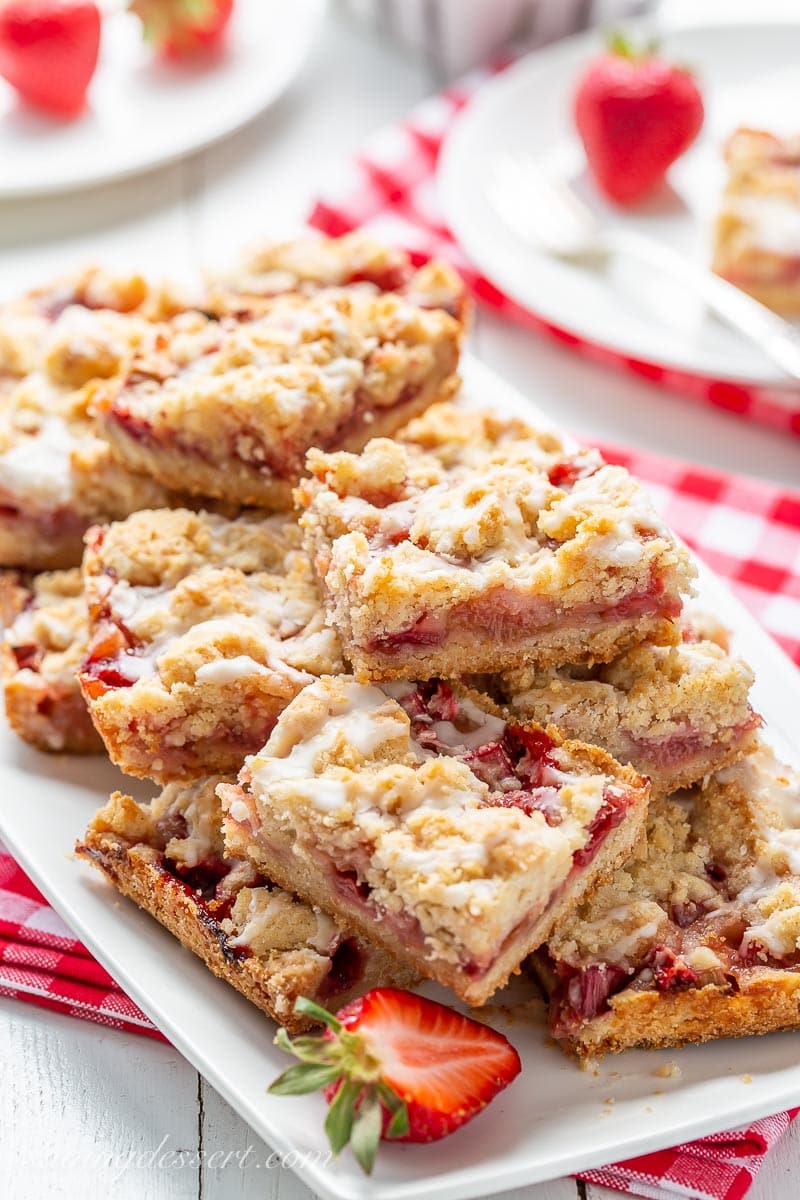 Crumble fruit bars stacked on a platter with strawberries