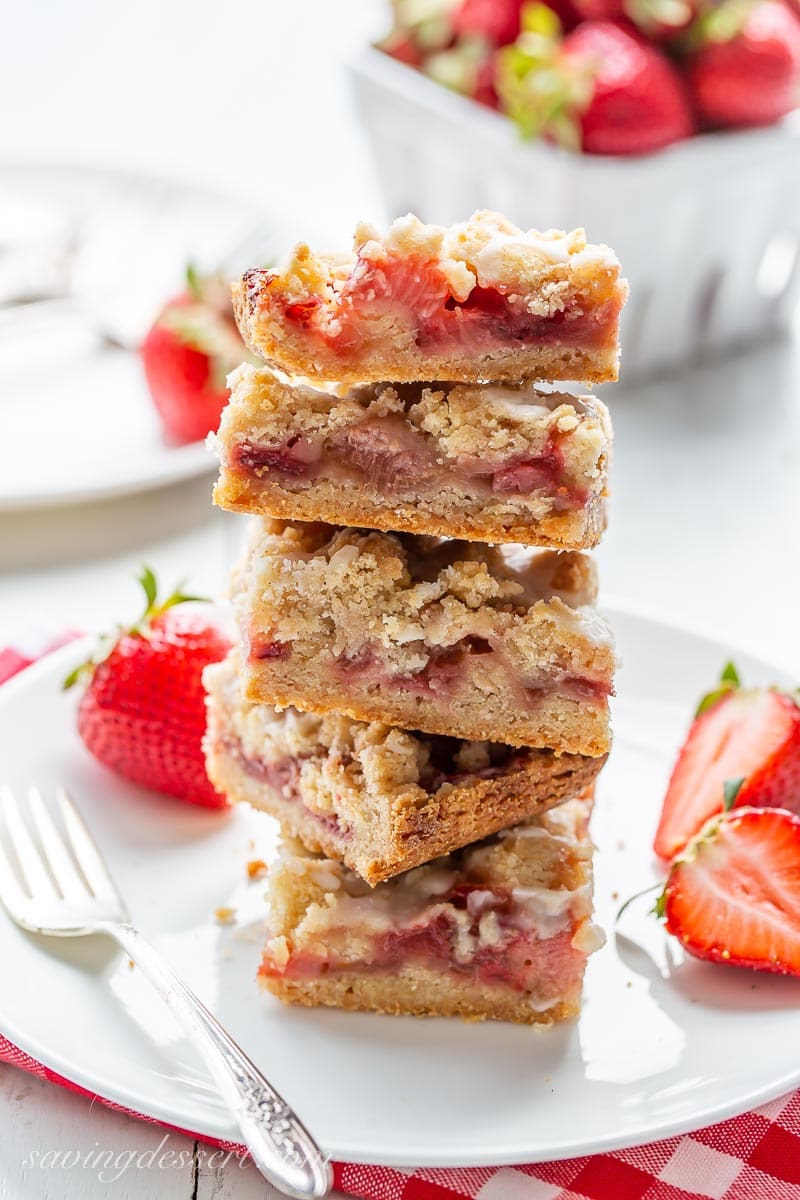 A stack of strawberry rhubarb crumble bars on a plate