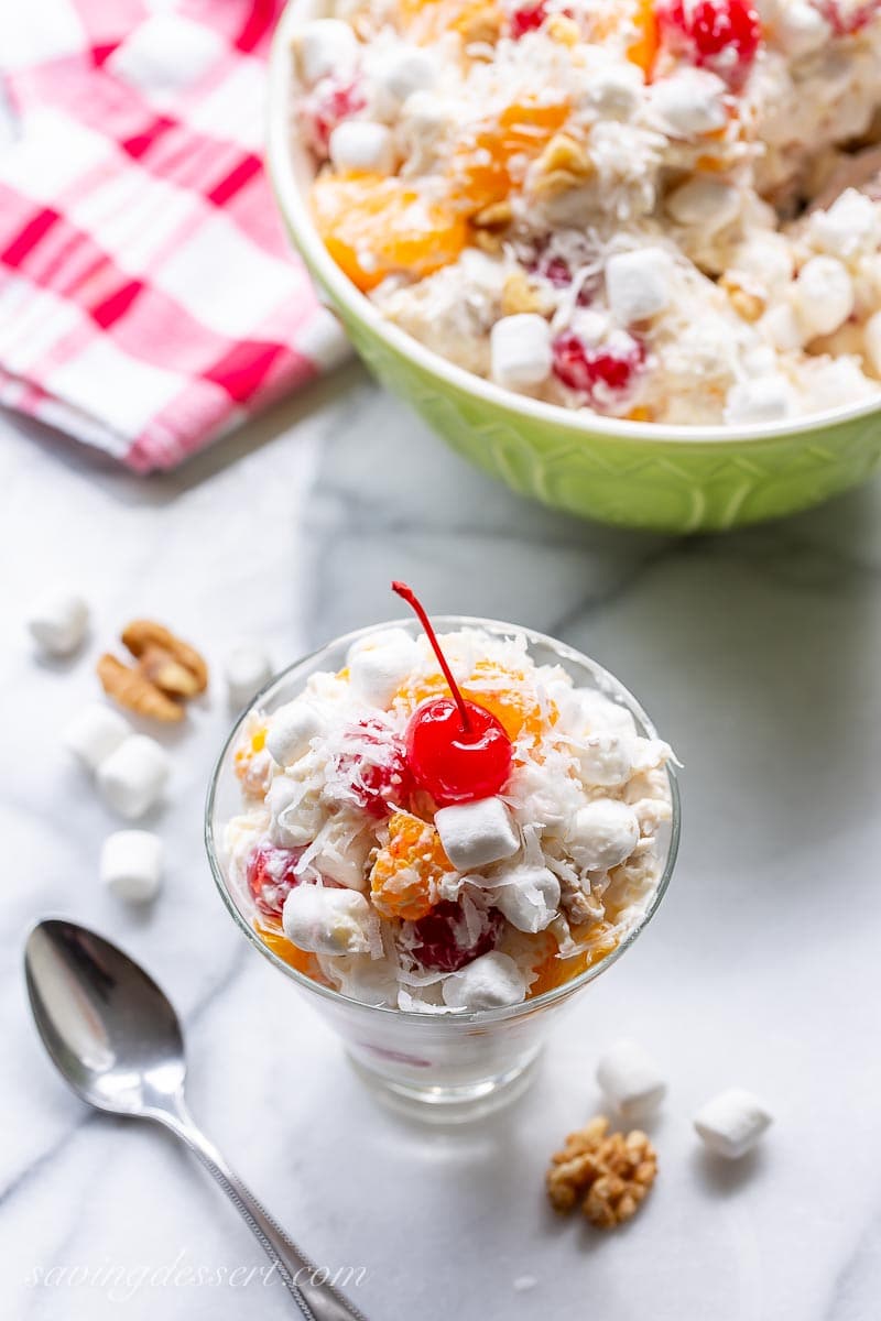 An overhead view of a glass filled with Fruit Salad with a cherry on top