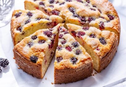 A sliced single layer blackberry cake with a crunchy sugary top