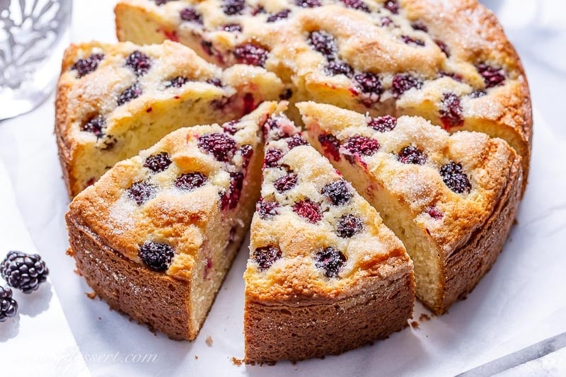 A sliced single layer blackberry cake with a crunchy sugary top