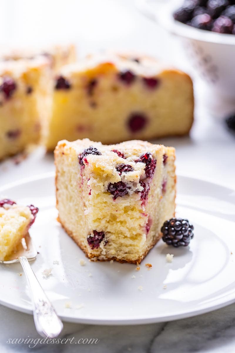 A piece of blackberry cake on a plate with a fork