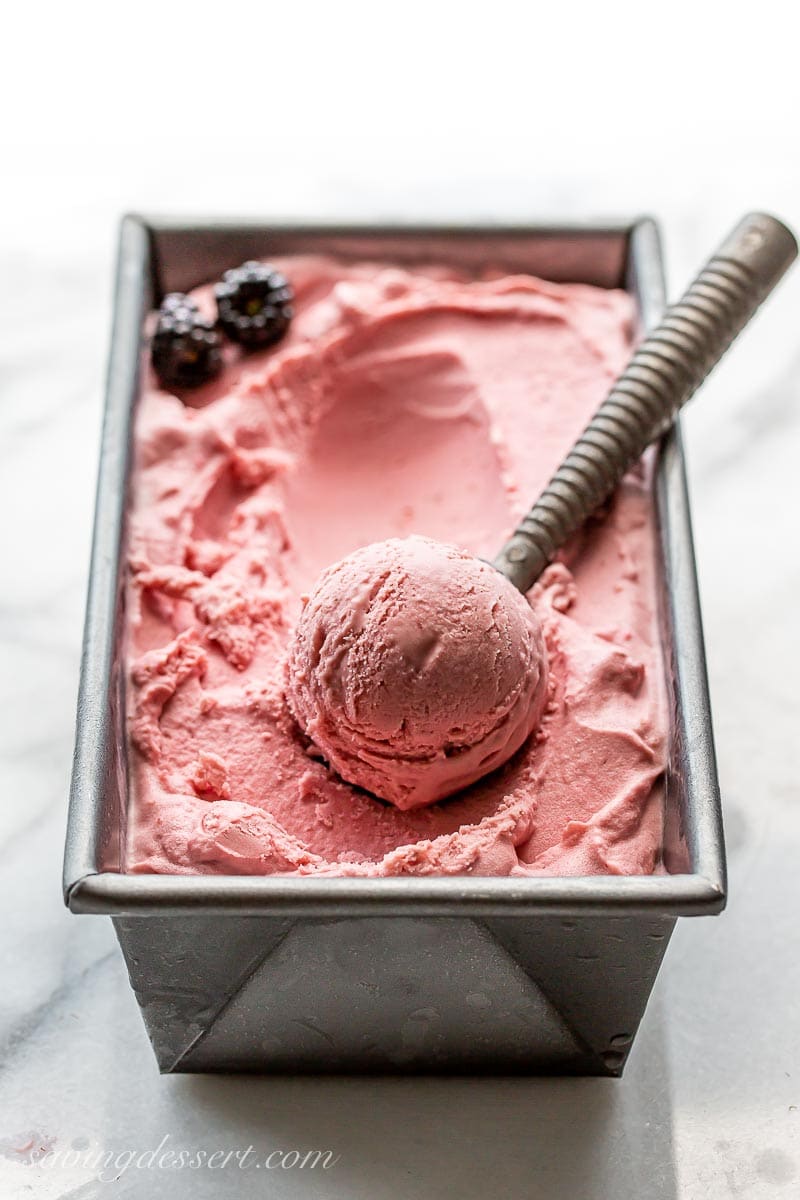 A big scoop of pink blackberry ice cream in a pan