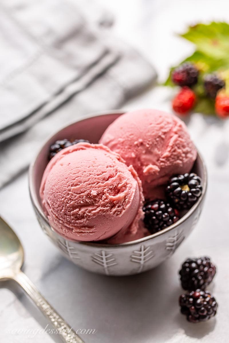A bowl of homemade Blackberry Ice Cream with fresh blackberries served on the side