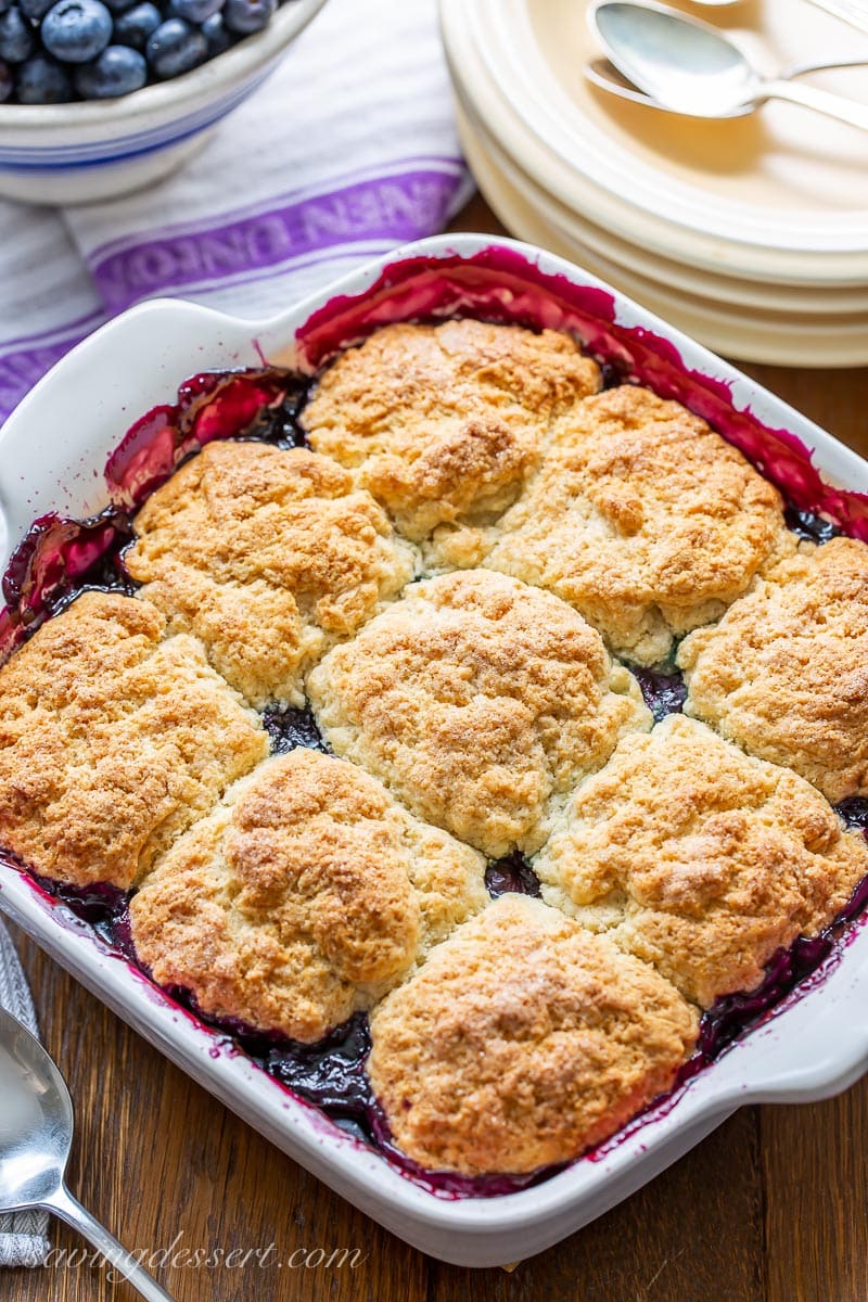 A casserole dish with biscuits floating in a pool of blueberry filling