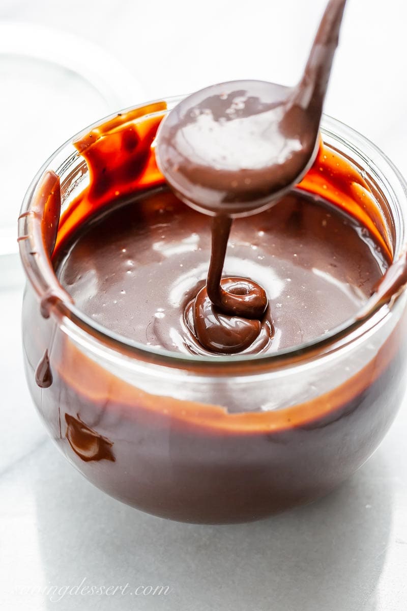 a wide-mouth jar filled with chocolate sauce and a ladle