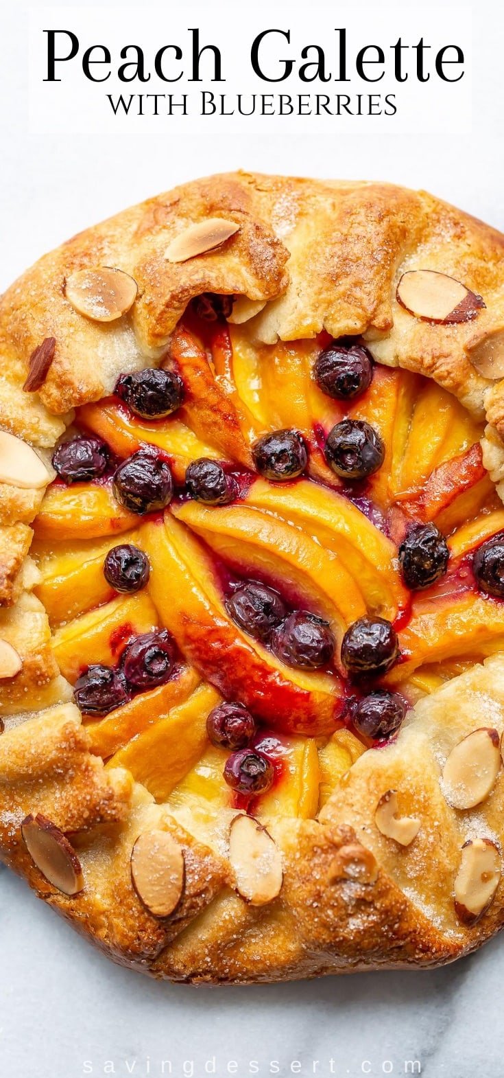 A close up shot of a peach galette with blueberries and sliced almonds