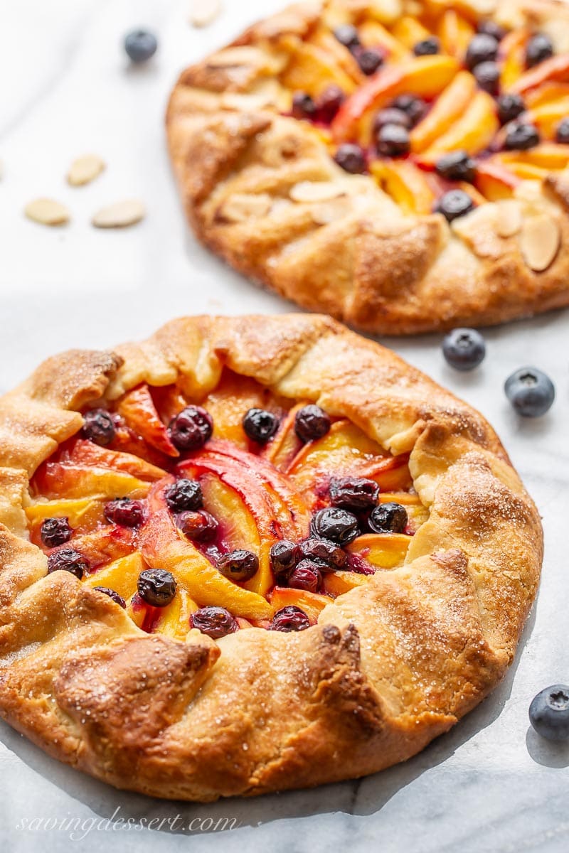 Rustic peach galettes with blueberries and sliced almonds