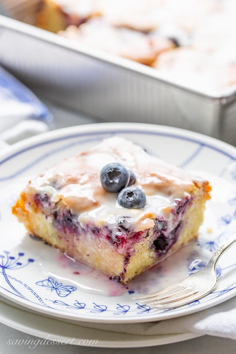 A slice of zucchini cake with blueberries and a buttermilk glaze