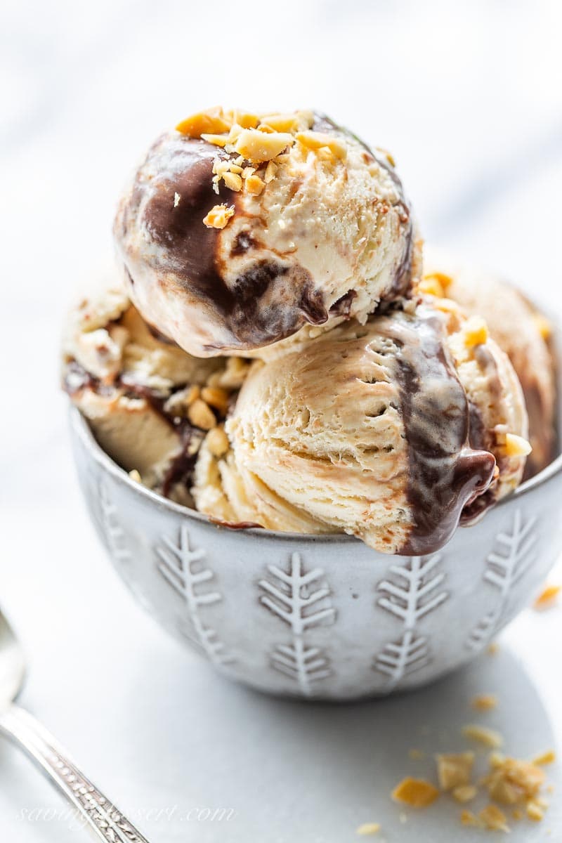 A bowl of peanut butter fudge ripple ice cream topped with chopped peanuts