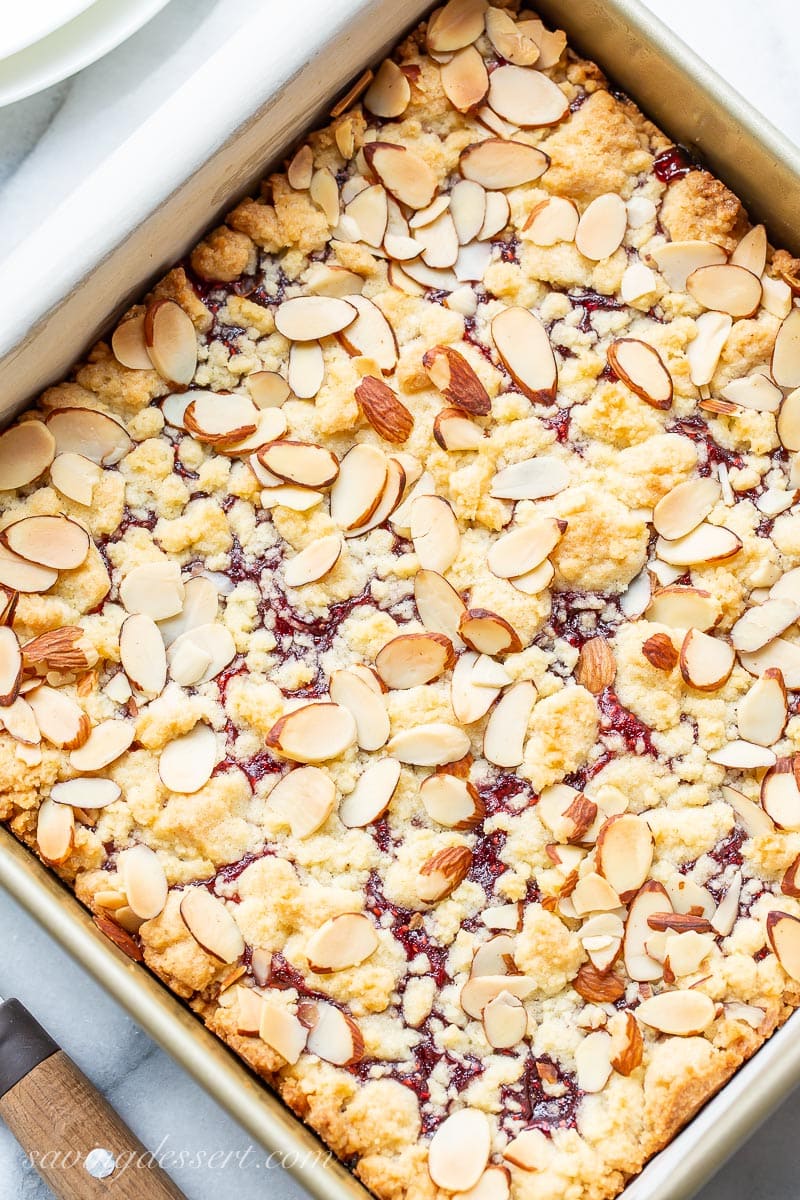 An overhead view of a square pan of jammy almond crumble bars