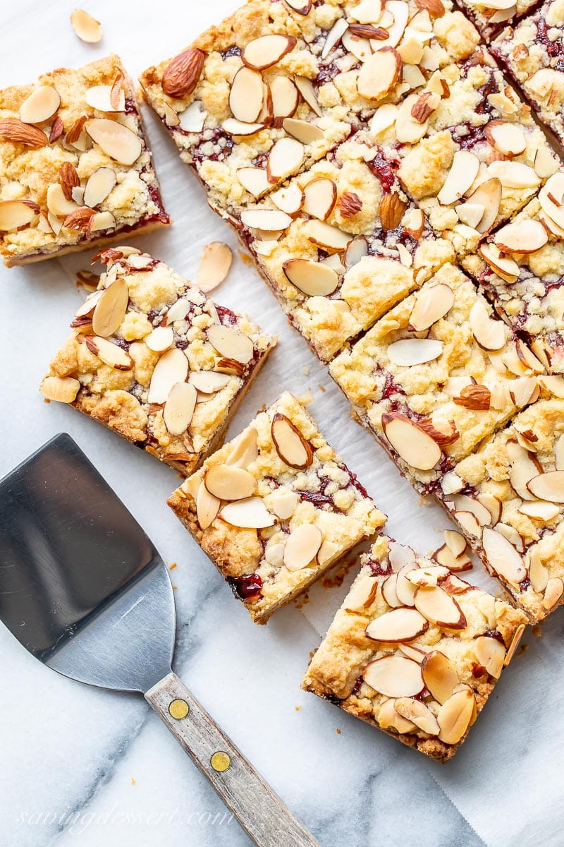 Raspberry Almond Squares on marble with a spatula