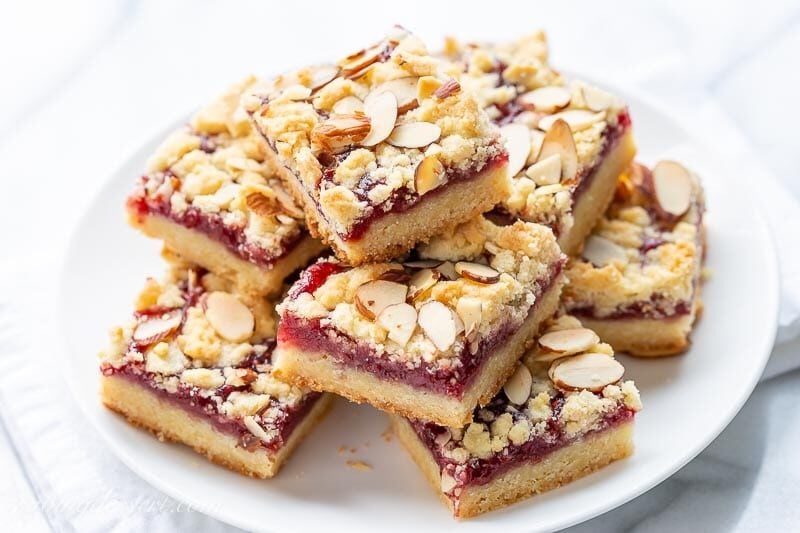 A plate of raspberry bars topped with sliced almonds