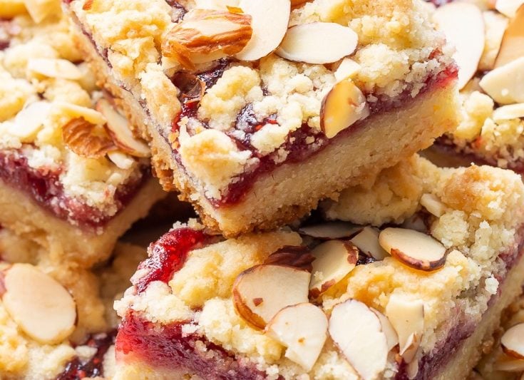 Raspberry squares in a stack with almonds on top