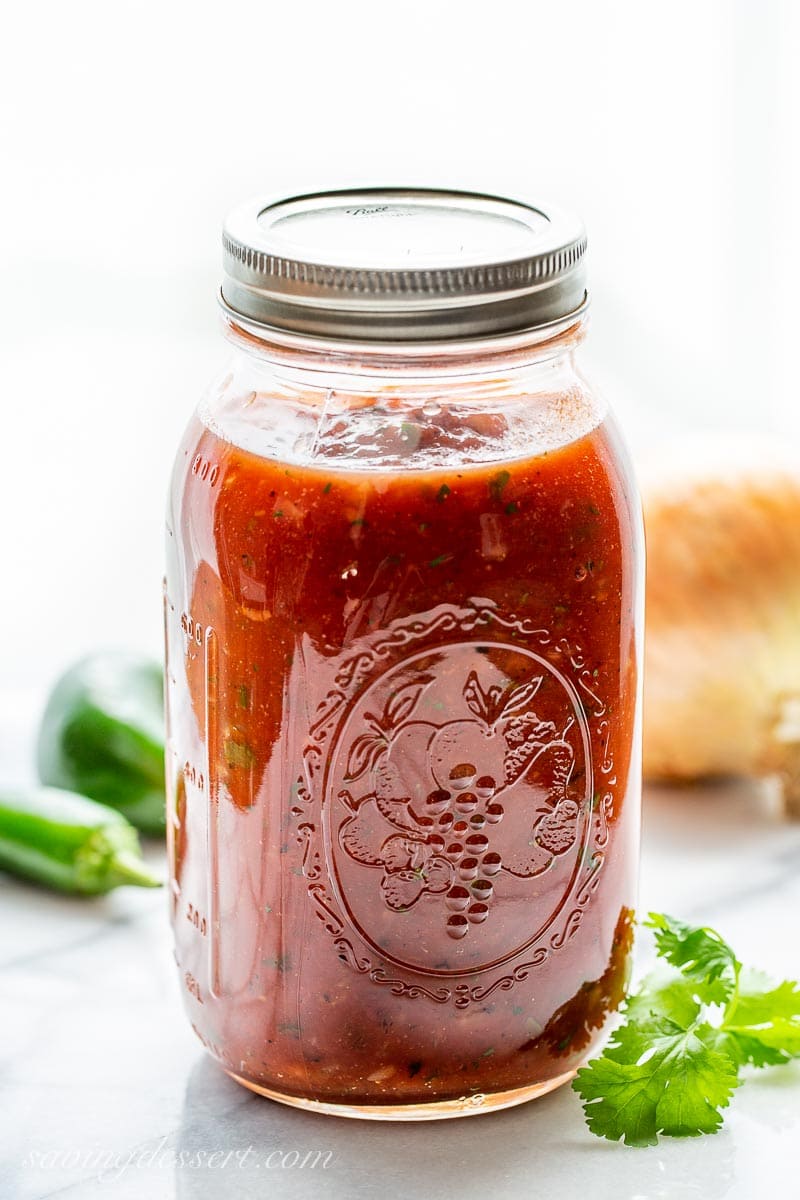 A large jar filled with homemade restaurant style salsa