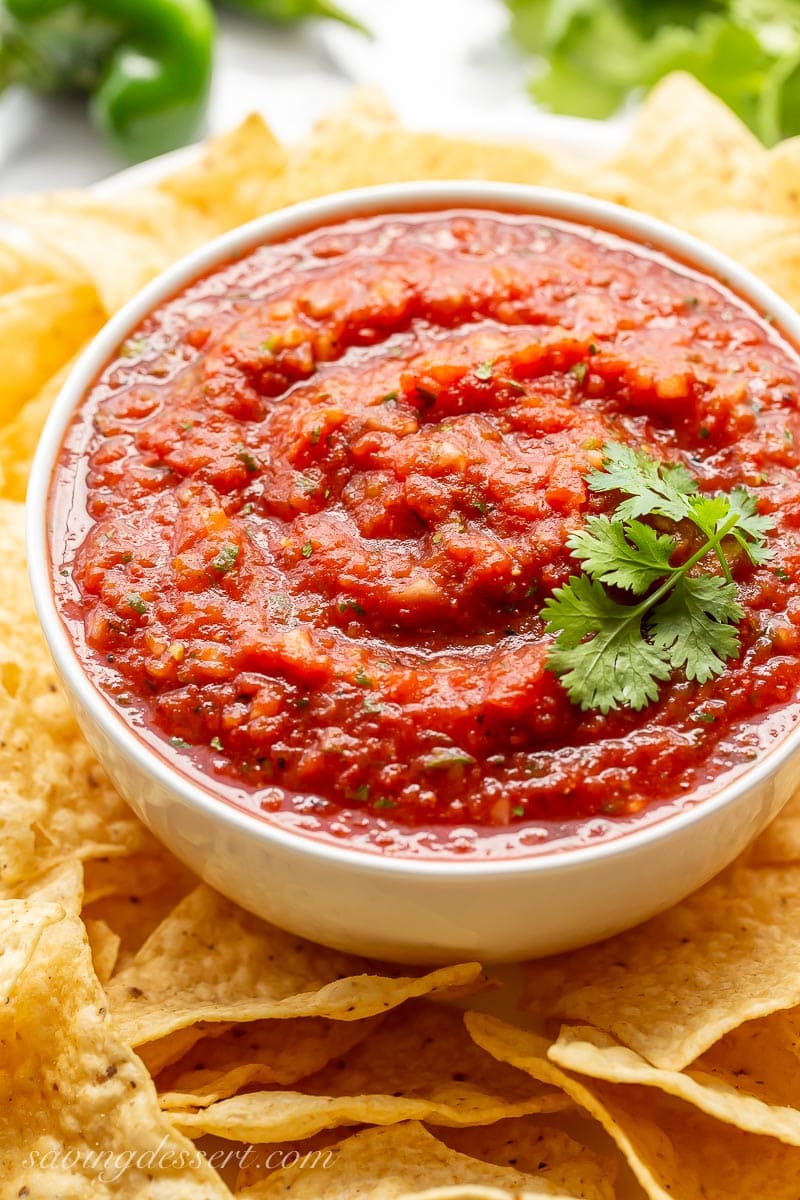 A big bowl of restaurant style salsa garnished with cilantro and served with tortilla chips
