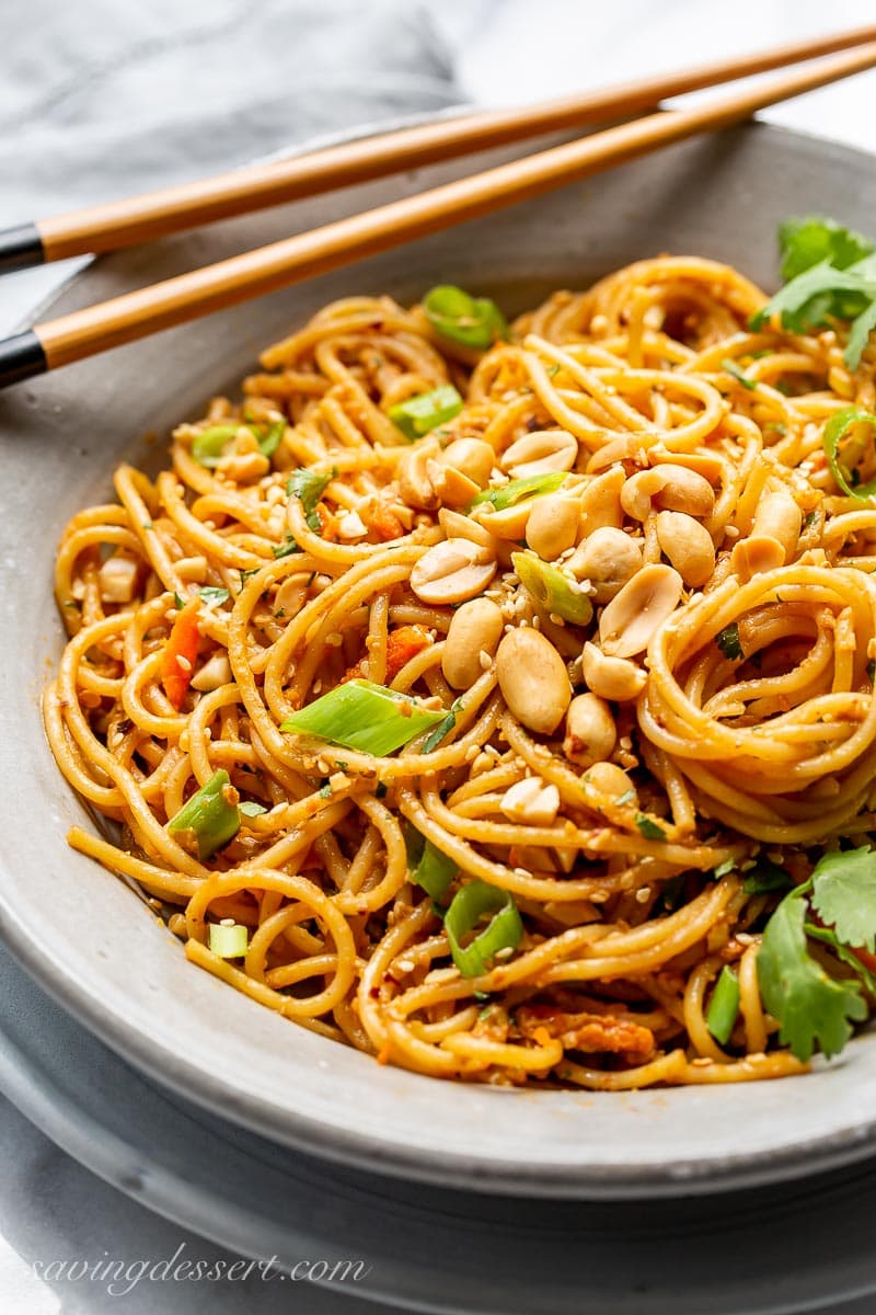 A bowl of spicy Thai style noodles in a peanut sauce