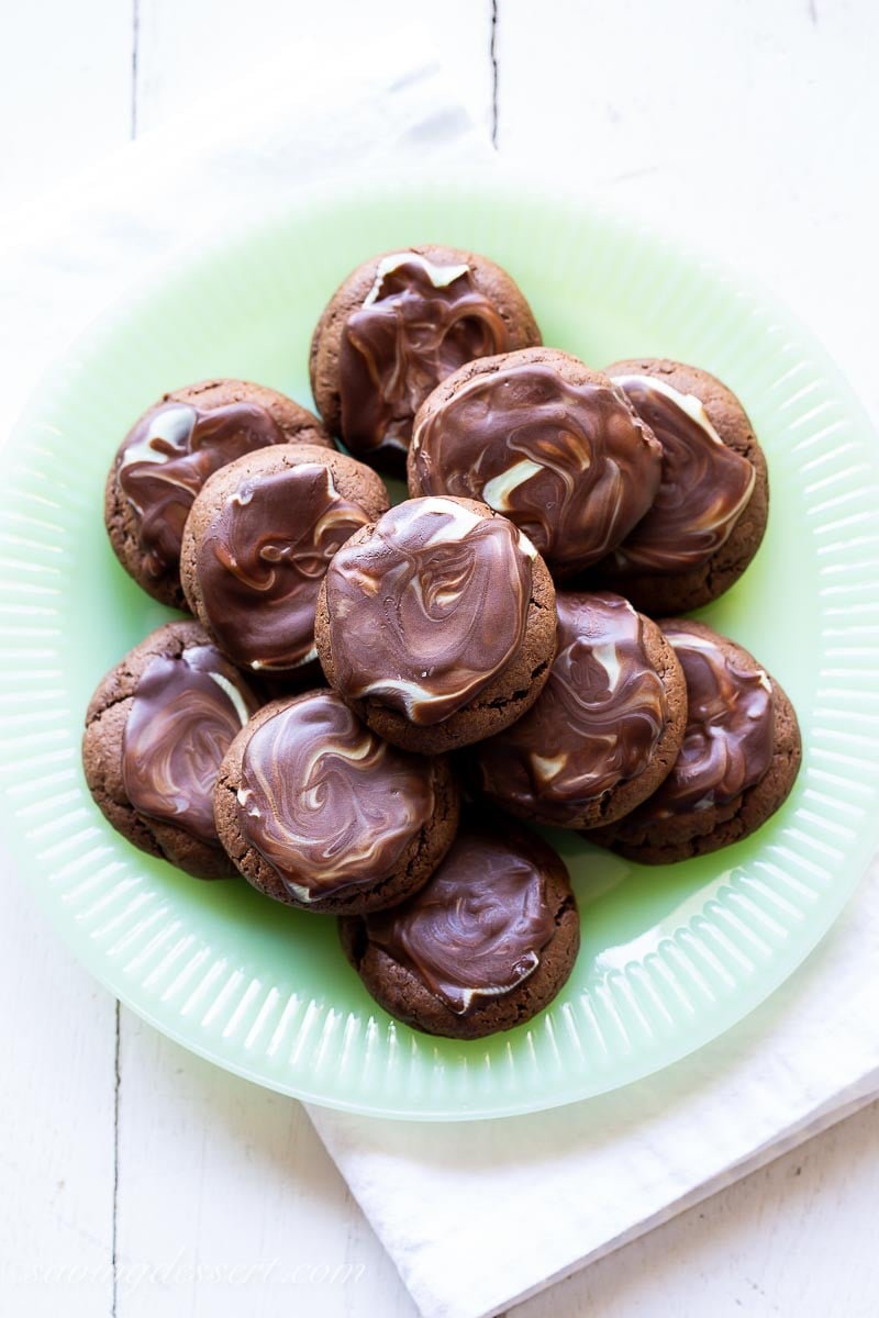 A plate of chocolate cookies with a chocolate mint icing swirled on top