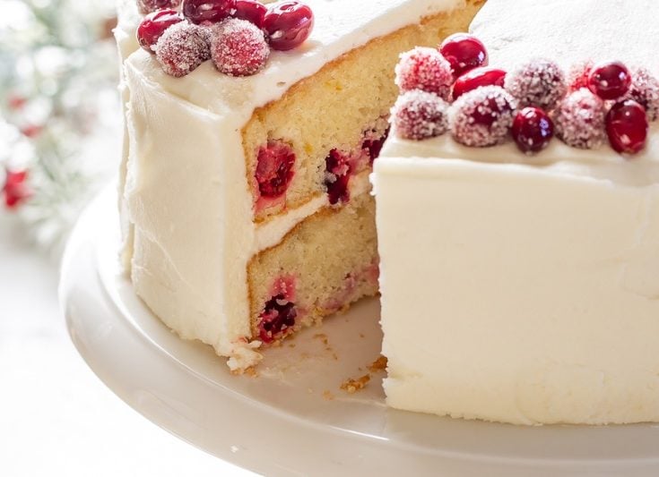 Cranberry Christmas Cake on a cake stand sliced showing the inside of the layers