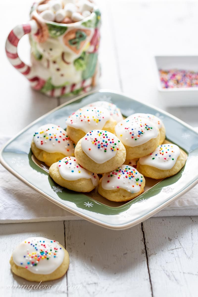 A plate of soft cake-like cookies with a lemon glaze and sprinkles