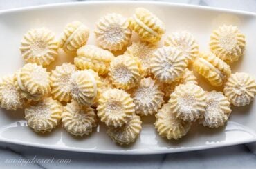 A plate of little lemon cookies dusted with powdered sugar