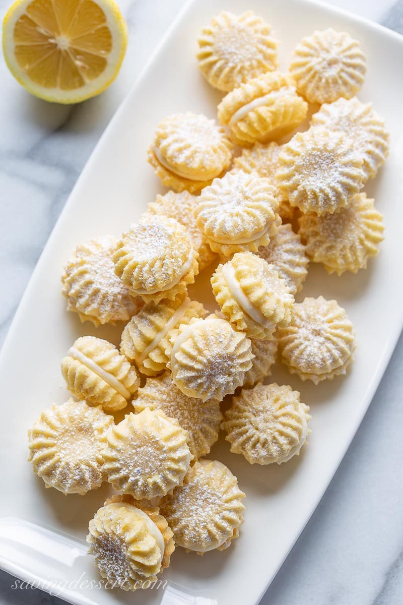 A platter of lemon cream filled cookies dusted with powdered sugar