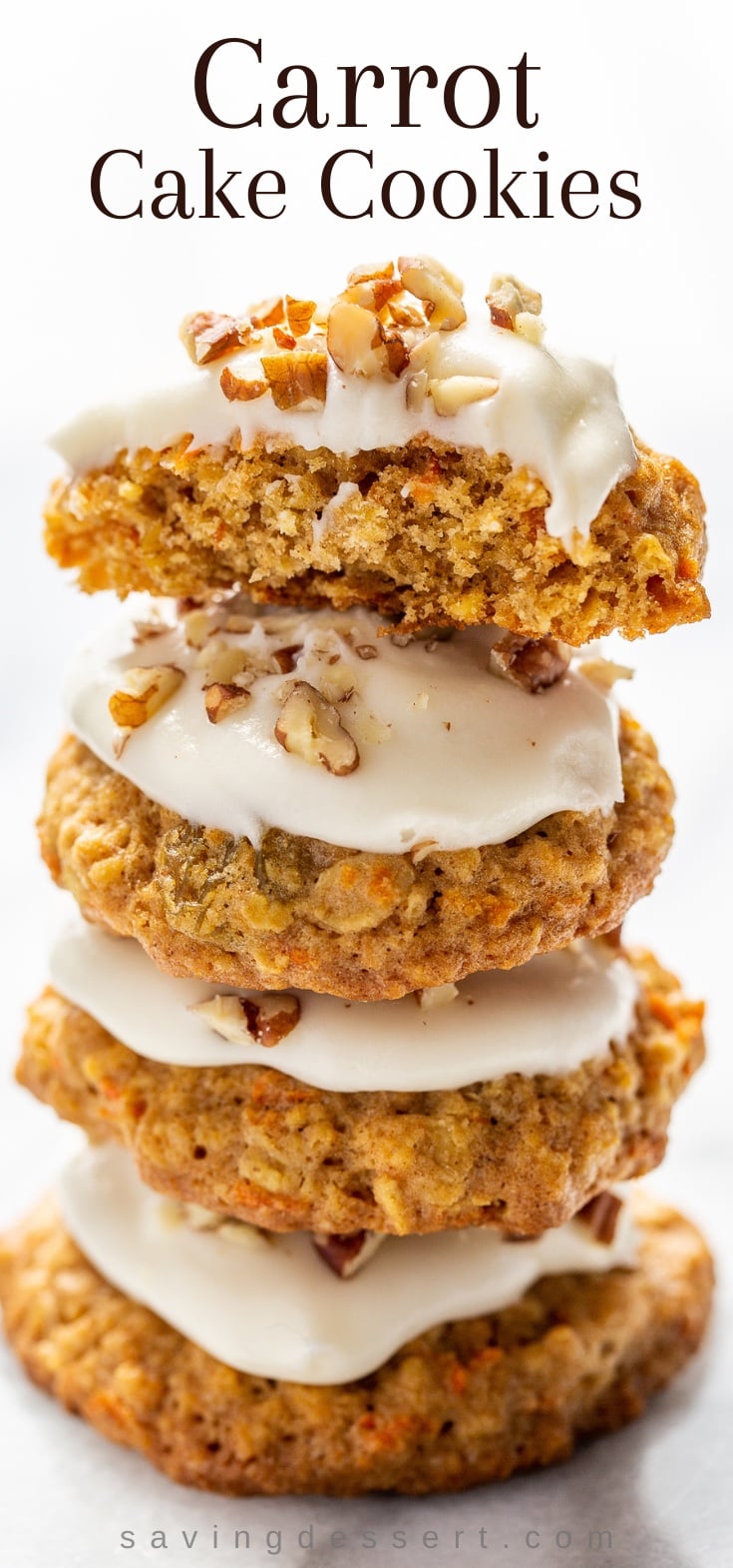 A stack of carrot cake cookies topped with cream cheese icing and chopped nuts