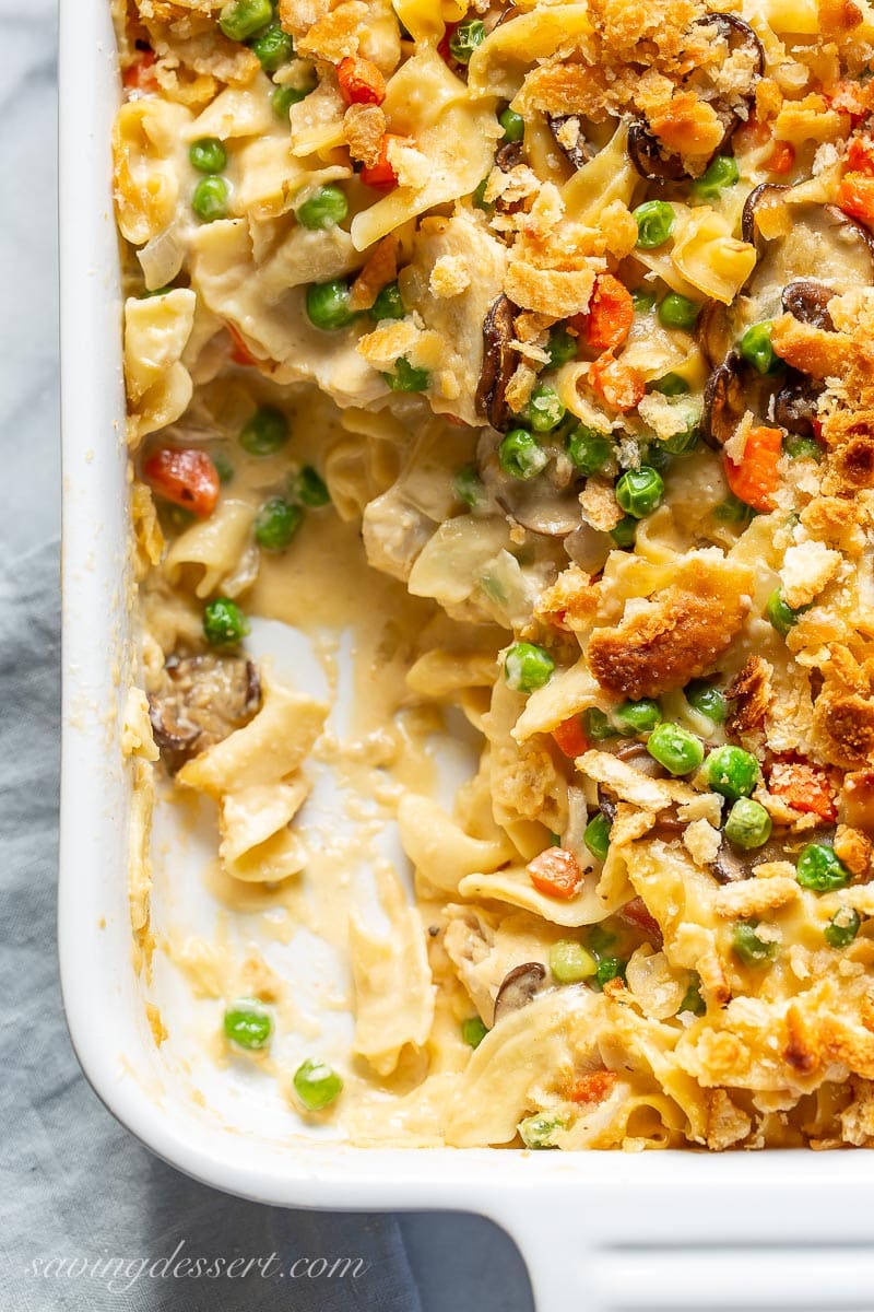 Overhead view of a cracker topped dish with egg noodles, chicken, peas, carrots and mushrooms in a creamy sauce