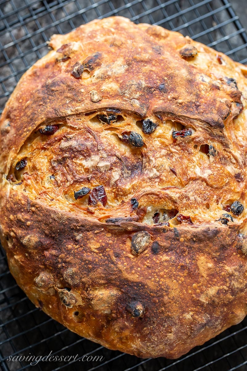 A golden brown loaf of Harvest Bread on a cooling rack