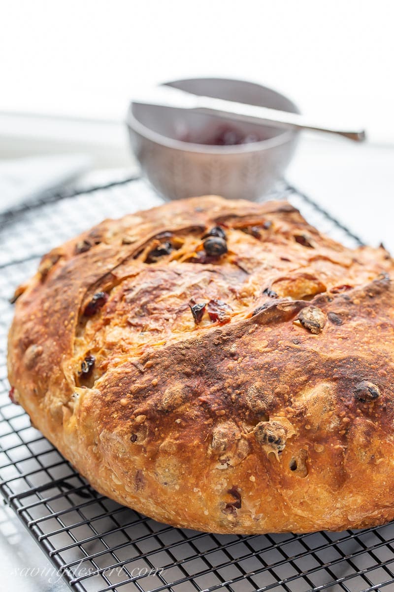 A rustic loaf of bread on a cooling rack