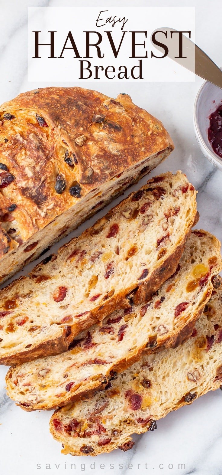 A round loaf of Harvest Bread sliced showing cranberries, nuts and raisins