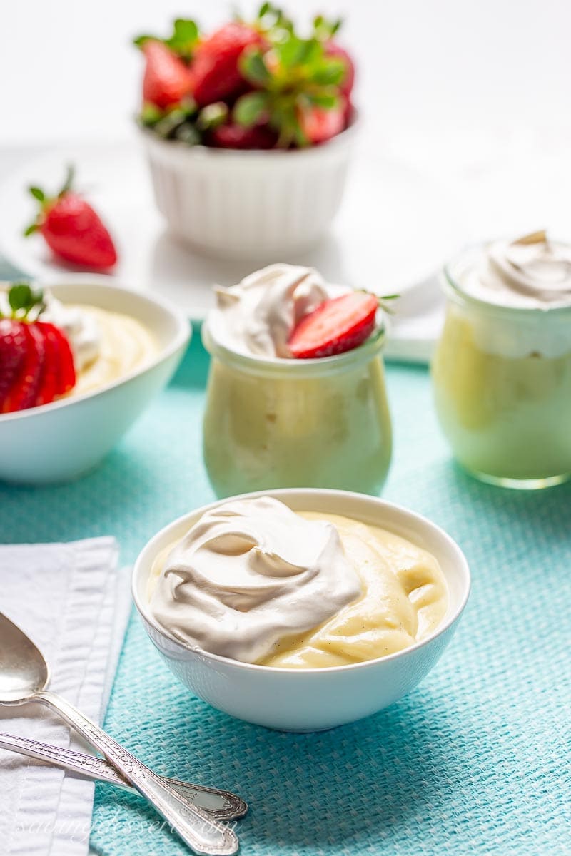 Bowls of pudding topped with whipped cream and strawberries